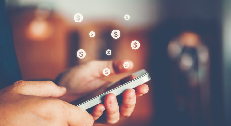 closeup of hand holding a smartphone with dollar signs rising from the screen