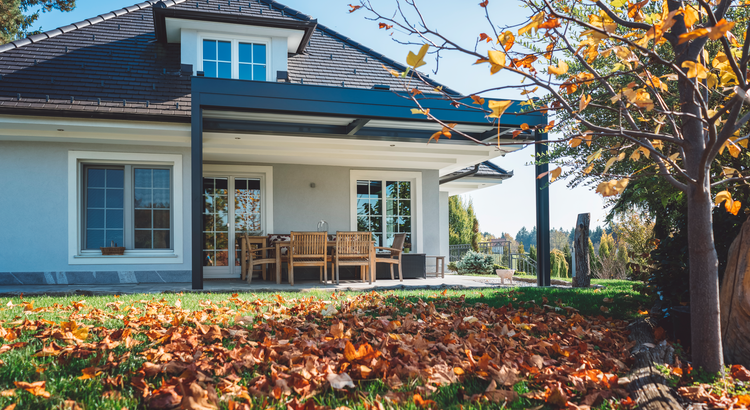 front of house with fallen leaves in the yard